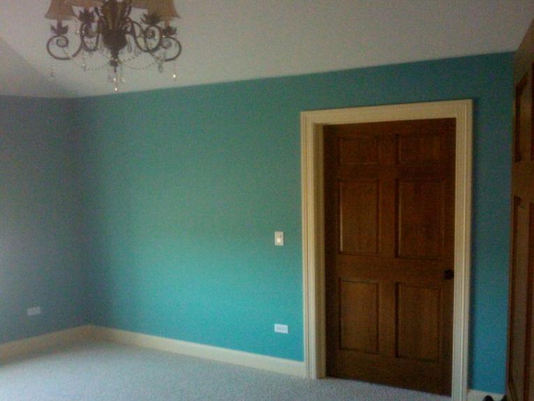 Picture of an aqua colored room with white trim and stained doors